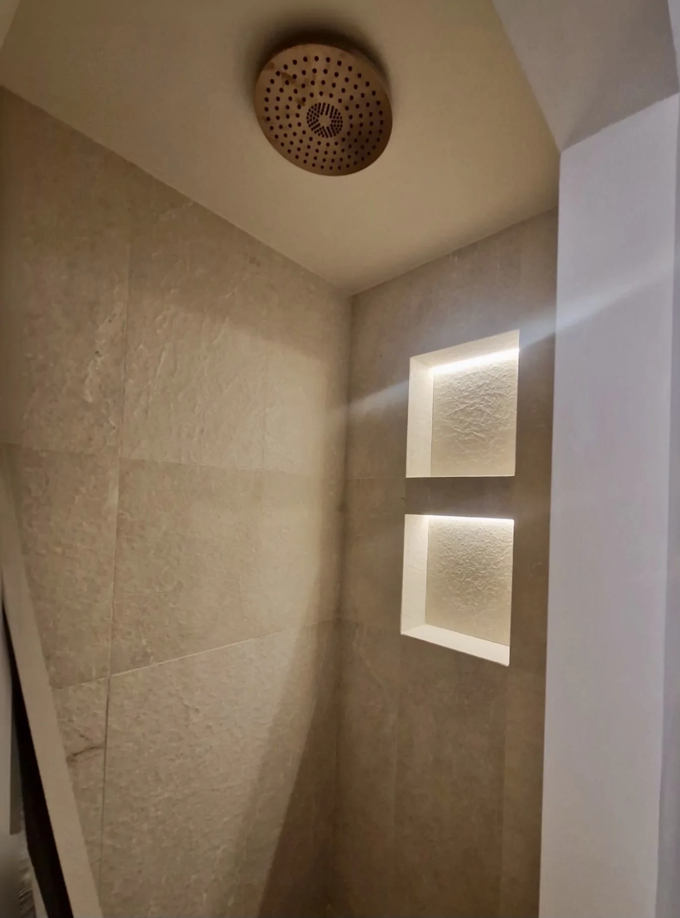 Ducha de obra con hornacinas iluminadas