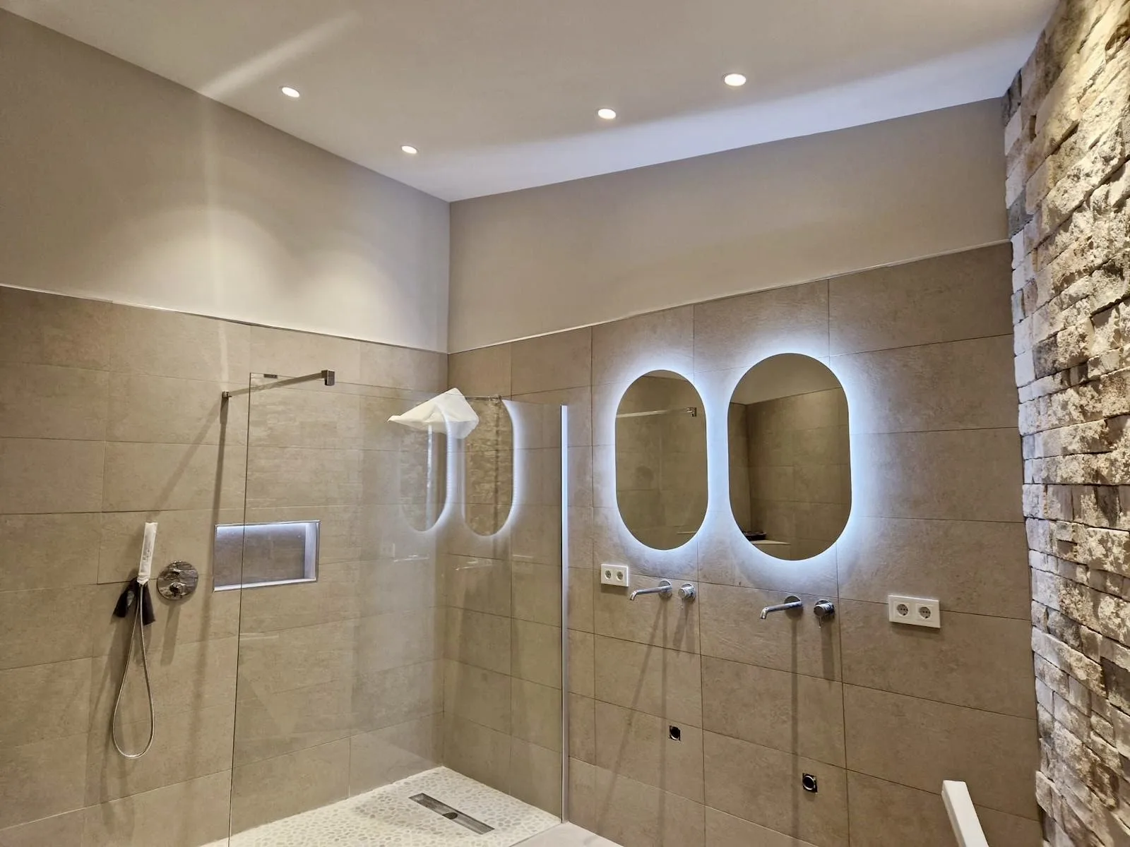 Baño de piedra natural con doble espejo retroiluminado